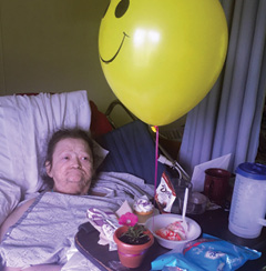 resident in her room enjoying mothers day meal with balloons