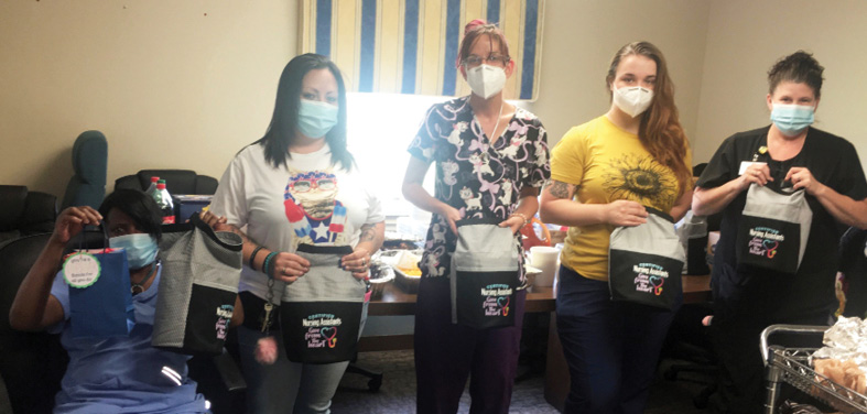 Christian Heights CNAs standing in a row with goodie bags