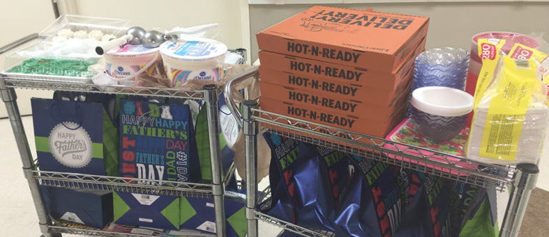 cart full of pizza boxes and gift bags for Fathers Day Celebrations