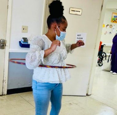 young woman doing the hula hoop in at Christian Heights Facility