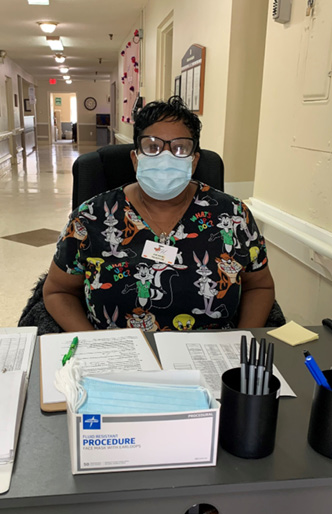 Receptionist Kimberly Babbs sitting at her desk at Christian Heights Nursing and Rehab